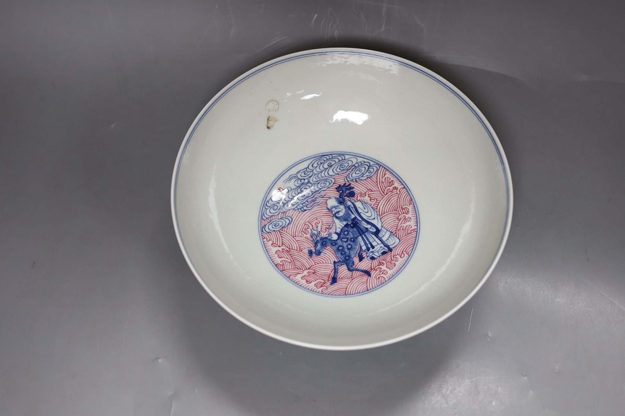 A Chinese underglaze blue and puce enamelled 'eight immortals' bowl, 22cm diameter